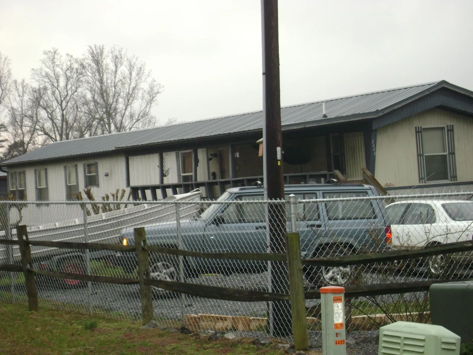 Dark metal roof on a long single story building behind a chain link fence in Windsor